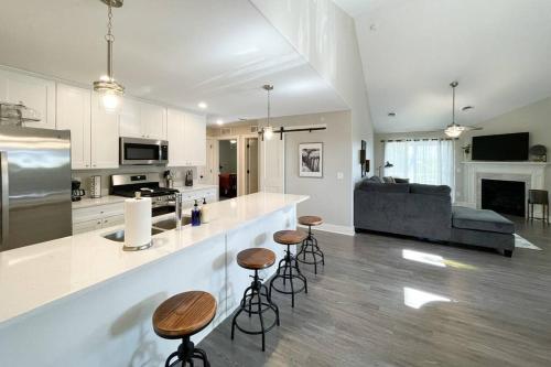 a kitchen and living room with a counter and stools at New Beautiful 3 Bedroom Condo in Bettendorf in Bettendorf