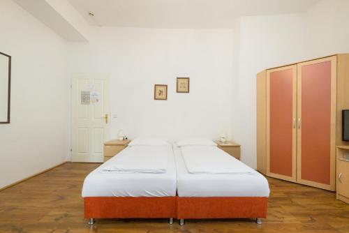 a bedroom with a bed and cabinets and a television at Pension Votiv in Vienna