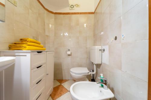 a bathroom with a white toilet and a sink at Casa di Jennifer 3 in Parma