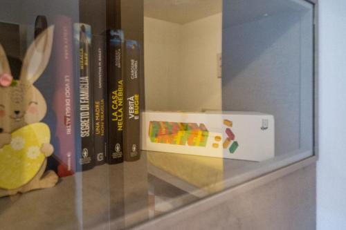 a shelf with books and a box on it at Casa di Jennifer 3 in Parma