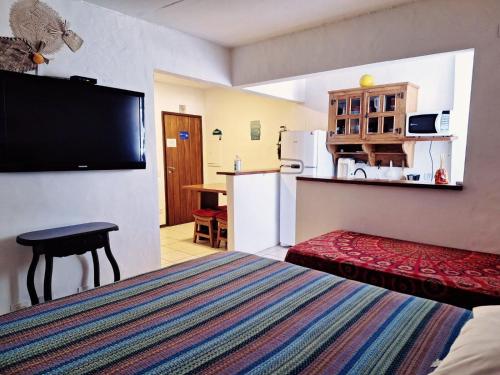 Habitación de hotel con cama y cocina en Apartamento Queen Centro Histórico - Vila Ilhabela, en Ilhabela