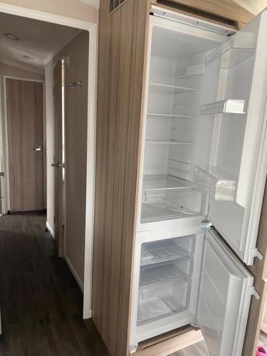un réfrigérateur vide avec une porte ouverte dans un couloir dans l'établissement North Shore, Skegness, new 8 berth caravan, à Lincolnshire