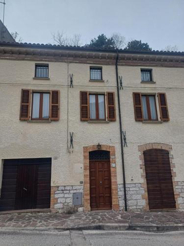 un edificio in mattoni con tre porte e finestre del garage di Casa Graziella a Costacciaro
