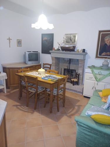 un soggiorno con tavolo e camino di Casa Graziella a Costacciaro