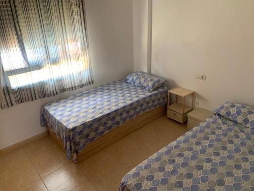 een slaapkamer met 2 bedden en een nachtkastje bij Belle maison de vacances in Grao de Castellón