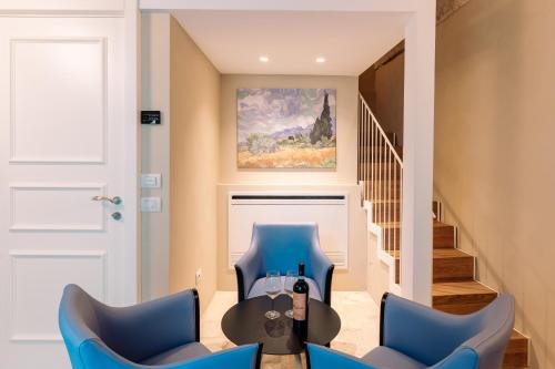 a living room with two blue chairs and a table at Aeris Suite & Relax in Polignano a Mare