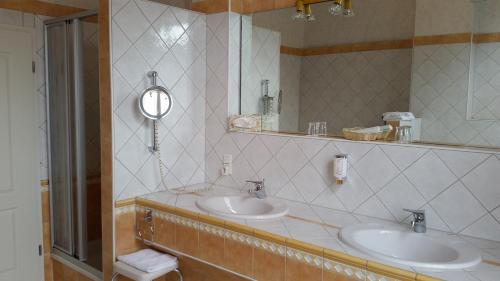 a bathroom with two sinks and a mirror at Villa Sophienhöhe in Kerpen