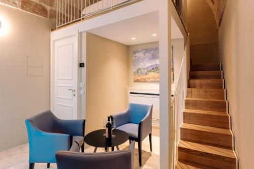 a room with a table and chairs and a staircase at Aeris Suite & Relax in Polignano a Mare