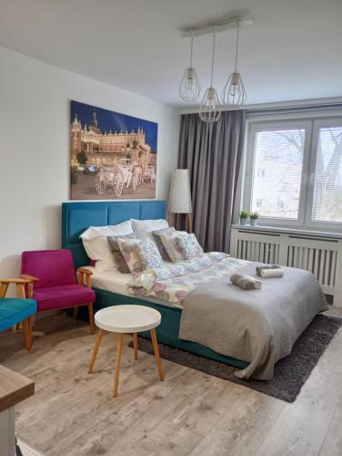 克拉科夫的住宿－Wilenska śródmieście，一间卧室配有一张大床和一张紫色椅子