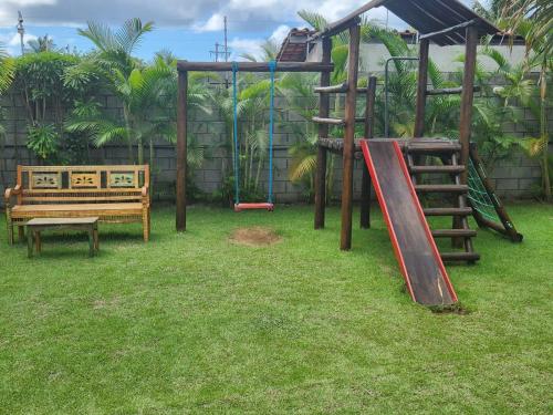 a park with a playground with a slide and benches at Village Verano Guarajuba in Guarajuba
