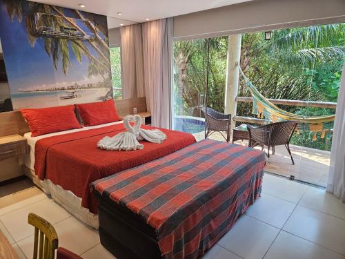 a bedroom with a bed and a large window at Villas do Pratagy in Maceió