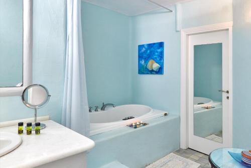 a white bathroom with a tub and a sink at Yades House Paros in Naousa