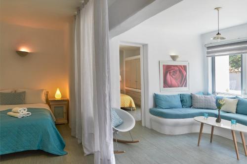 a bedroom with a blue bed and a couch at Yades House Paros in Naousa