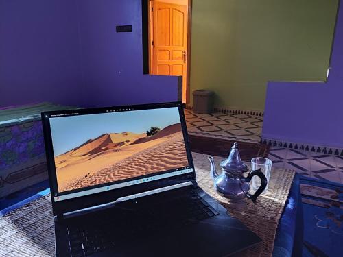 un computer portatile seduto sopra un tavolo di Hostel Merzouga Tifinagh a Merzouga