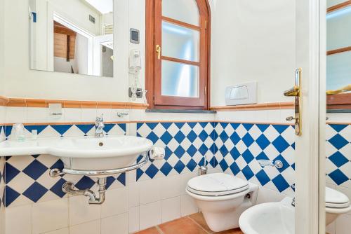 a bathroom with a toilet and a sink at Hotel la Pietra restaurant in Fosdinovo