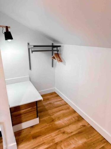 a white room with a bench and a wooden floor at Etherington Suites in Elora