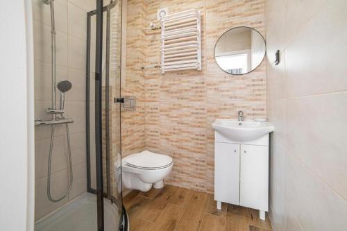 a bathroom with a toilet and a sink and a shower at Grobla -Old Town by Grand Apartments in Gdańsk