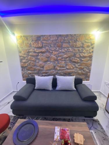 a couch in a room with a stone wall at Alexandra apartment in Athens