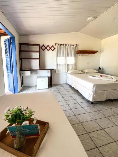 a large bedroom with a bed and a table at Pousada Les Alizes in Icaraí