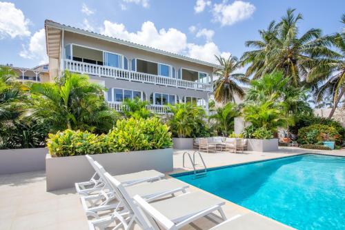 een villa met een zwembad en palmbomen bij JT Curacao Apartments in Jan Thiel