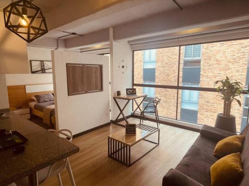 uma sala de estar com um sofá e uma mesa em APTOPOR606 - Encantador apartamento tipo loft - Chapinero - Wifi - TV em Bogotá