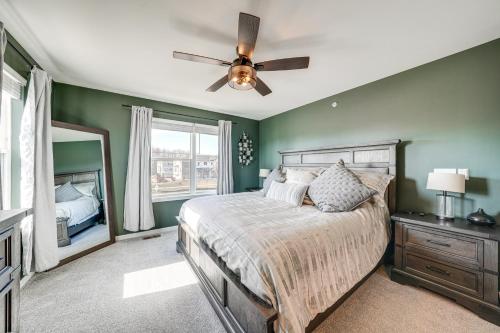 Schlafzimmer mit grünen Wänden und einem Bett mit Deckenventilator in der Unterkunft Pet-Friendly Warrenville Townhome with Gas Grill! in Warrenville