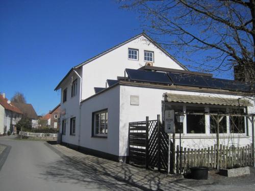 a white building with a black roof on a street at Gasthaus Rogge in Lemgo