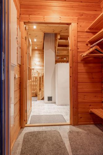a hallway in a log cabin with a ladder at Piiponkartano by Hi Ylläs in Ylläsjärvi