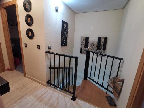 a hallway with a staircase with black railings at Apartamento en la playa de Oropesa in Oropesa del Mar