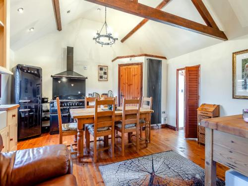 a dining room with a table and a kitchen at Bluebell Lodge - Uk46412 in Burgh le Marsh