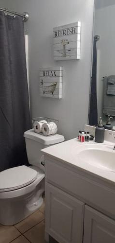 a white bathroom with a toilet and a sink at Relax and Unwind in Bryan