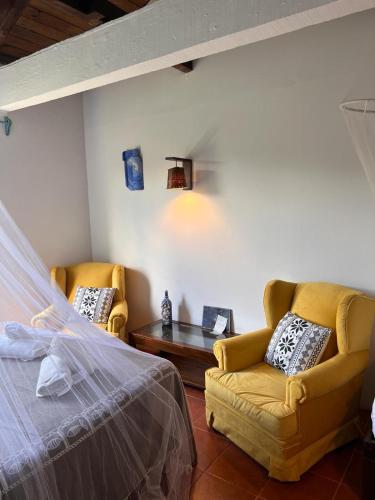 a bedroom with two chairs and a bed and a table at Guesthouse Entre Campo y Mar in La Coronilla