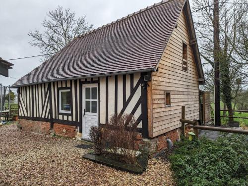 ein kleines Haus mit einem schwarz-weißen Dach in der Unterkunft charmante maison Normande in Livarot