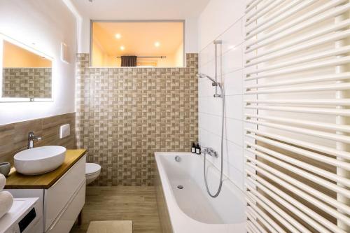 La salle de bains est pourvue d'une baignoire, de toilettes et d'un lavabo. dans l'établissement Design Appartment Altstadtperle auf Wunsch mit Parkplatz, à Pirna
