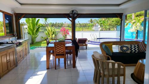 a kitchen and dining room with a table and chairs at Villa Fendal Jasri in Jasri