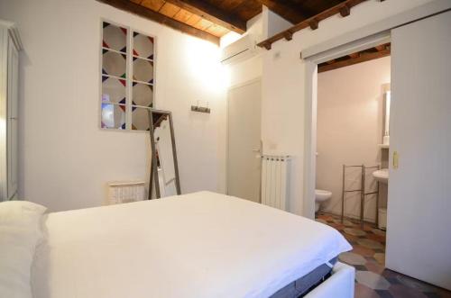 een witte slaapkamer met een bed en een badkamer bij F1 - Santa Croce one bedroom apartment for couples in Florence
