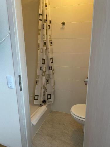 ein Bad mit einem WC und einem Duschvorhang in der Unterkunft Pension Feist Zimmer4 in Dagebüll