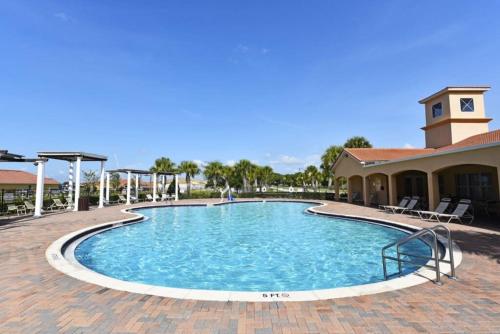 a pool at a resort with chairs and a building at Lovely Lakeside 4-Bed Pool Home at Villa Sol-3125 in Kissimmee