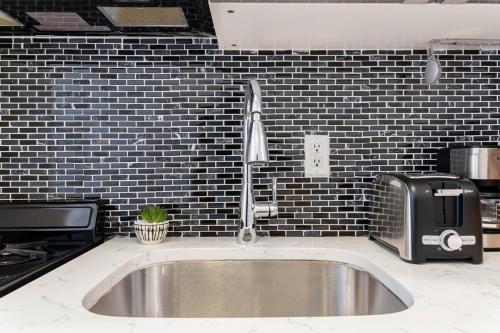a kitchen counter with a sink and a microwave at 26-4A New Studio prime 20's W D Shared Courtyard in New York
