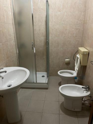 uma casa de banho com um lavatório, um WC e um chuveiro em AMLA “ Guesthouse “ em Shkodër