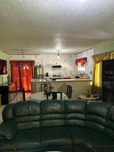 ein Wohnzimmer mit einem Sofa und einer Küche in der Unterkunft Casa Fransina in Blue Bay