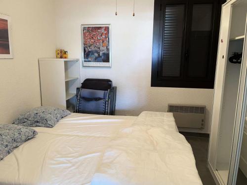une chambre avec un lit blanc et une chaise bleue dans l'établissement Résidence Palmyra - Appartement T2 au rez-de-chaussée à LE BARCARES-CAP COUDALERE MAE-9491, au Barcarès
