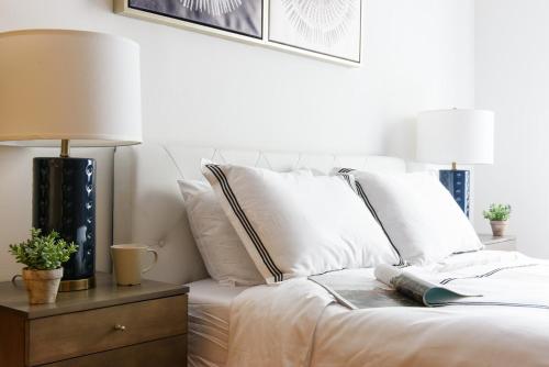 - un lit avec des oreillers blancs et un livre dans l'établissement 26-4B Newly Furnished 1BR W D Courtyard, à New York