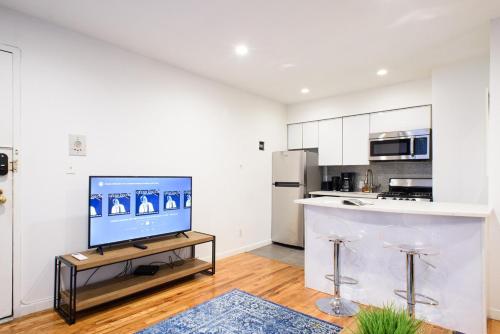 ein Wohnzimmer mit einem TV und einer Küche in der Unterkunft 26-4B Newly Furnished 1BR W D Courtyard in New York