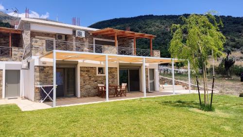 a house with a roof extension with a patio at Seastone Villas in Almiropótamos