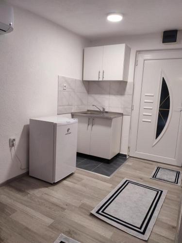 a kitchen with a white refrigerator and a door at City River View in Foča
