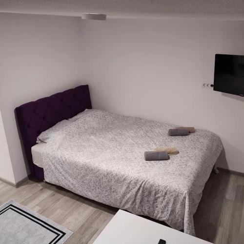 a bedroom with a bed with a purple head board at City River View in Foča