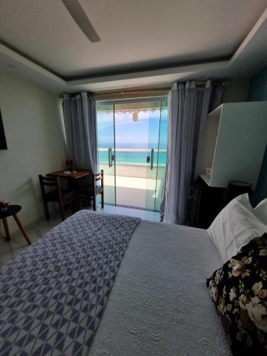 a bedroom with a bed and a view of the ocean at Hotel Aconchego Da Vila in Saquarema