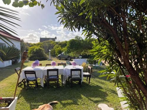 a table with purple flowers on it in a yard at Guesthouse Entre Campo y Mar in La Coronilla