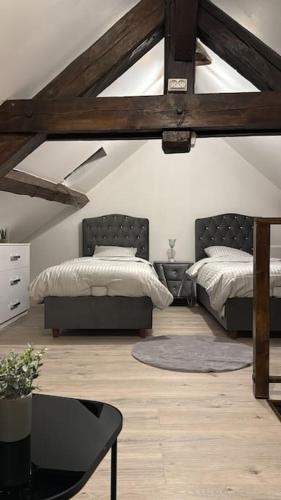 - une chambre mansardée avec 2 lits et une table dans l'établissement La maison du Bien être, à Bolbec